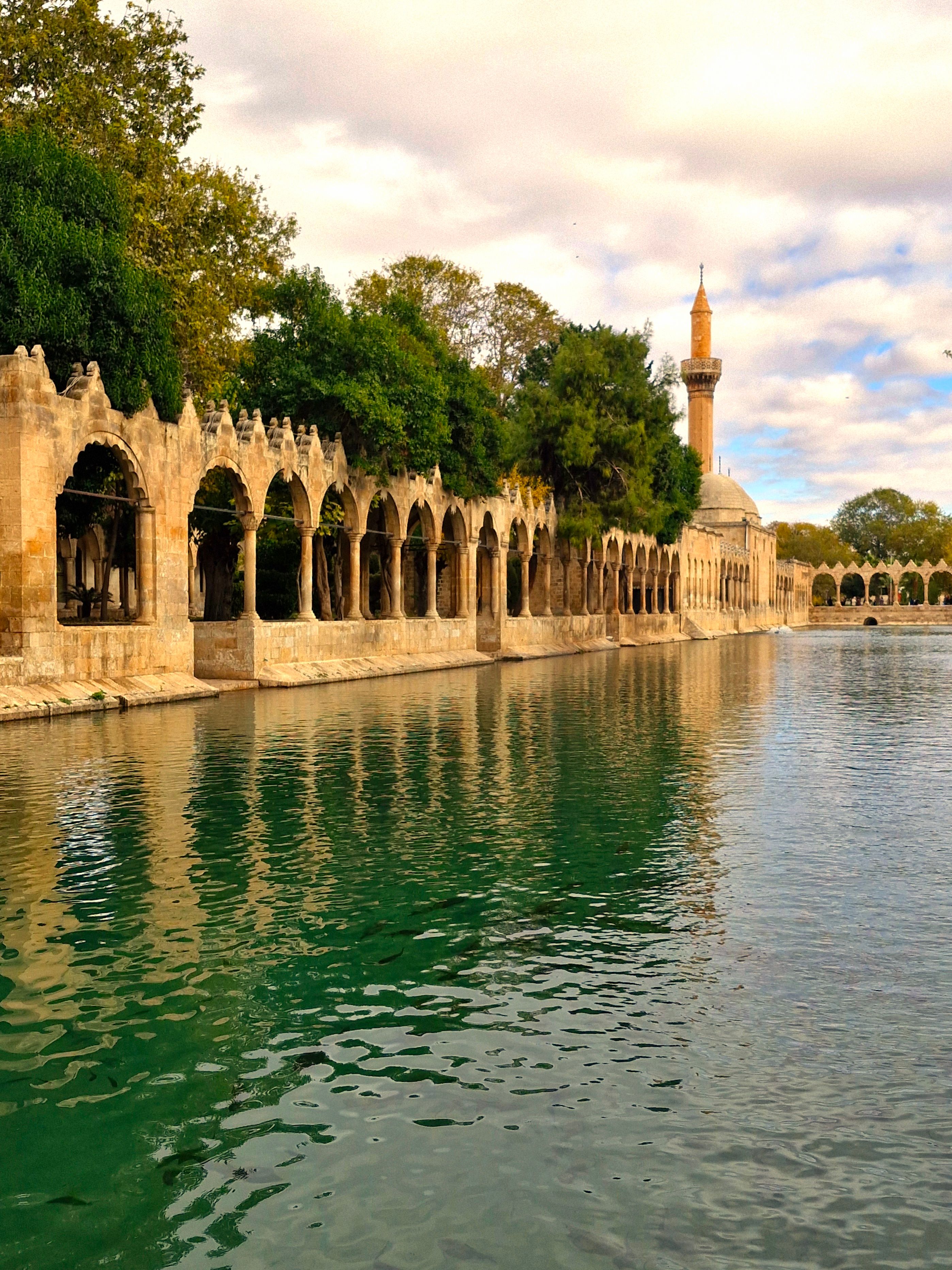 Beautiful reflection of the Halil-ur Rahman Mosque and arches in Sanliurfa's sacred pool.