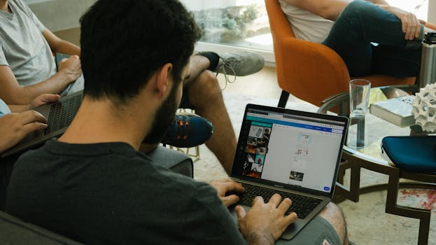 在现代办公室里，三名成年人正用笔记本电脑进行数字协作