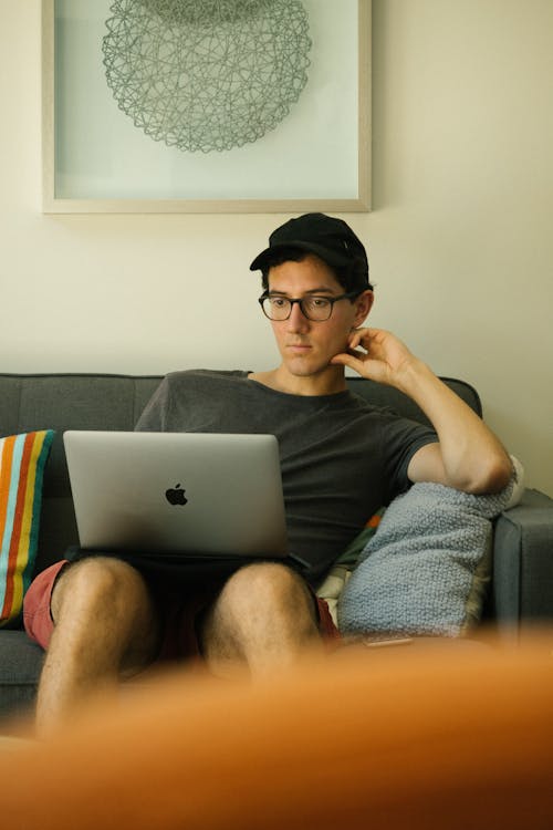 Man Using Macbook While Sitting On Sofa