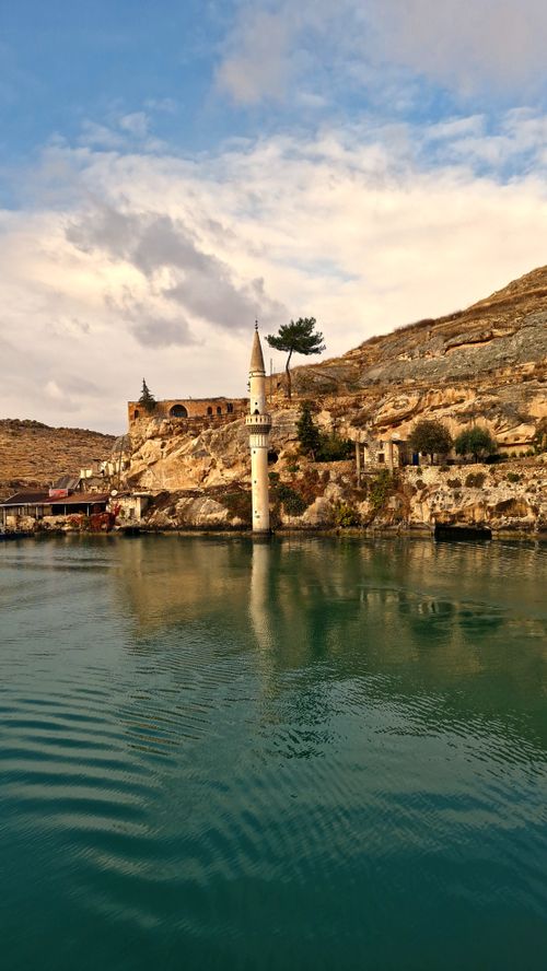 Free Scenic view of the submerged mosque tower in Halfeti with calm water and rocky landscape. Stock Photo