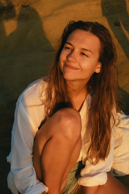 Фотография женщины, сидящей на песке