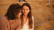 日落时分，一对年轻夫妇在沙地上共享了一段亲密的时光