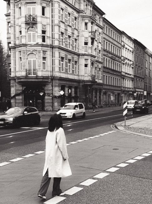 Black and white image of a city street in Dresden, Germany with a pedestrian crossing.