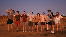 一群年轻人在海滩上欣赏着风景优美的日落