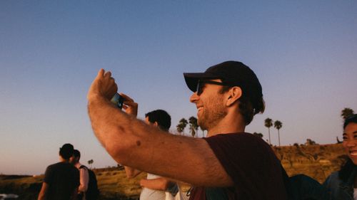 Free Group of friends enjoying a sunny day outside, captured in candid joy. Stock Photo