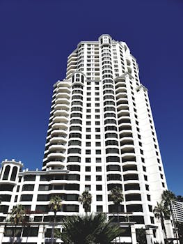 一座现代摩天大楼矗立在清澈的蓝天下，其建筑设计独特