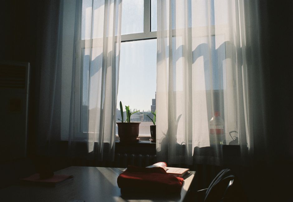 A serene interior with sunlight streaming through sheer curtains, soft shadows cast.