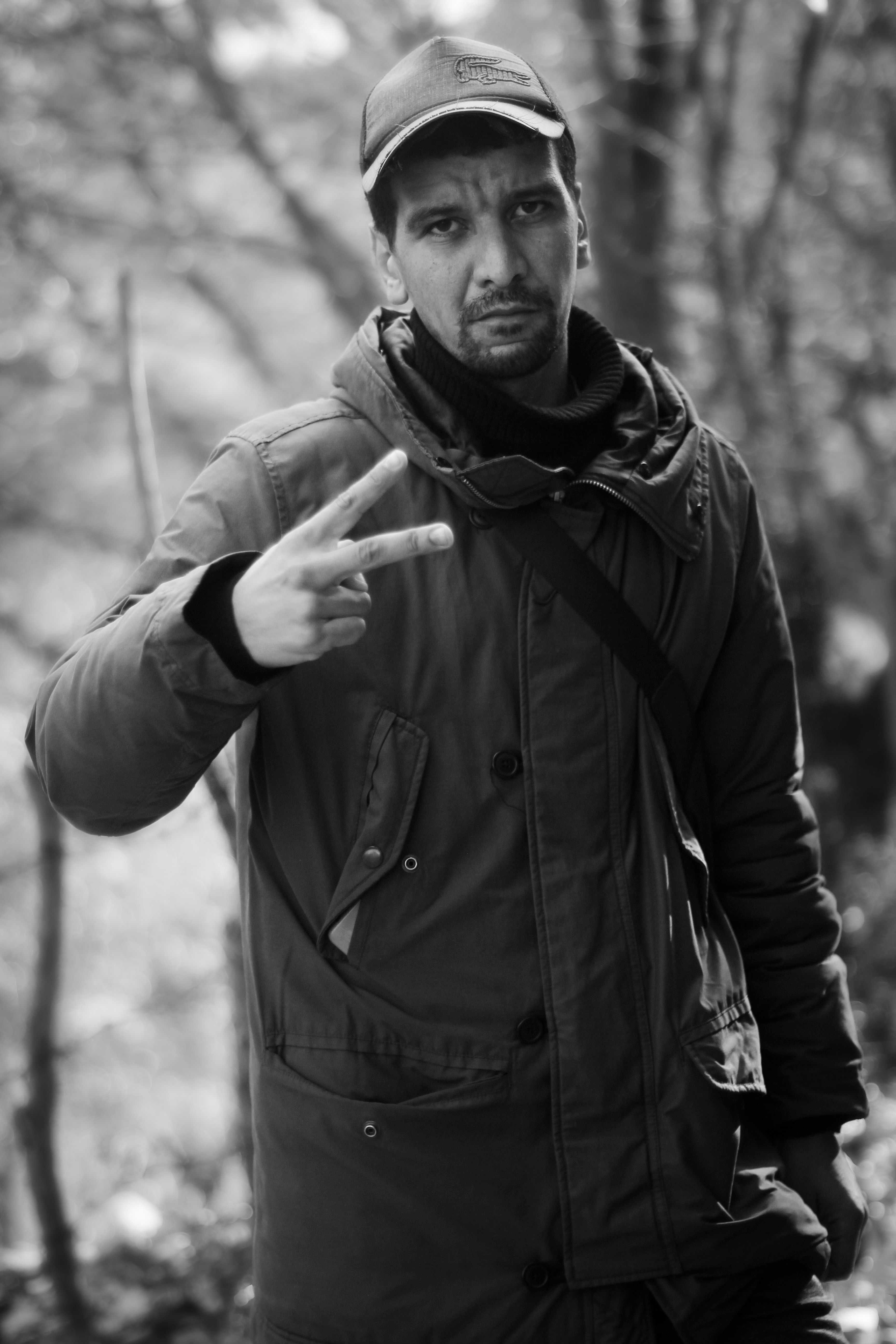 A man outdoors making a peace gesture, captured in Skikda Province, Algeria.