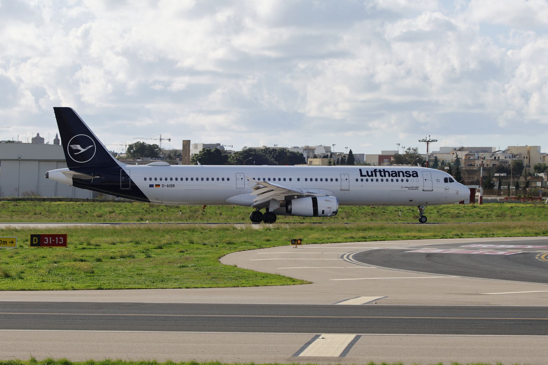 Lufthansa airplane on the runway ready for takeoff on a clear day at an airport.