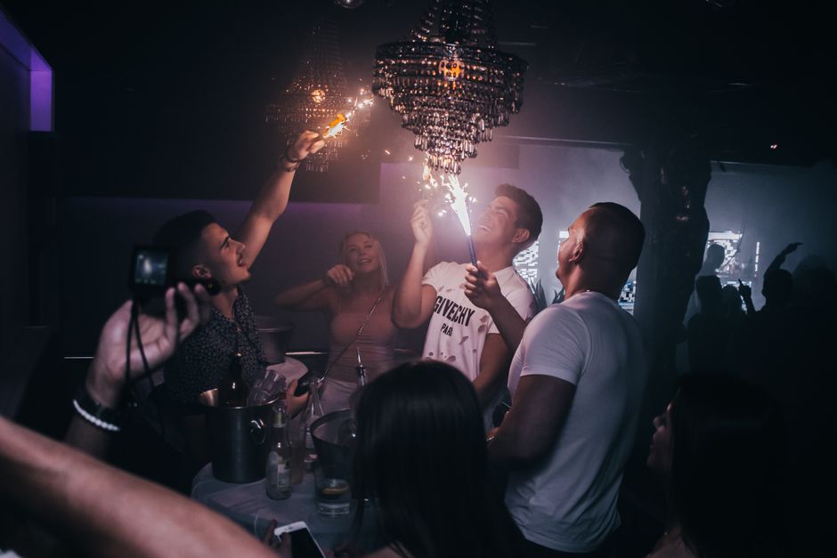 Partygoers celebrate with sparklers in a lively nightclub in Karlshamn.