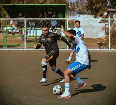 Players engaging in a competitive soccer game on a sunny day.