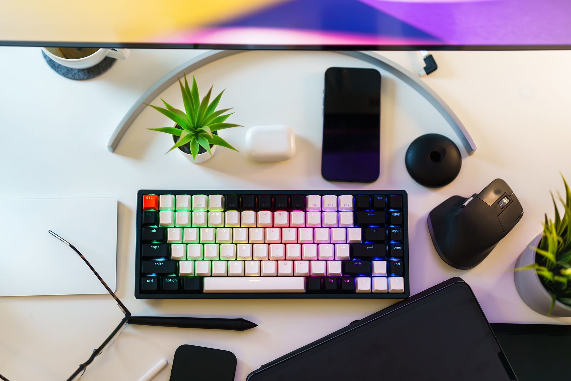 A neat desk setup with keyboard, smartphone, and plants, ideal for work-from-home productivity.
