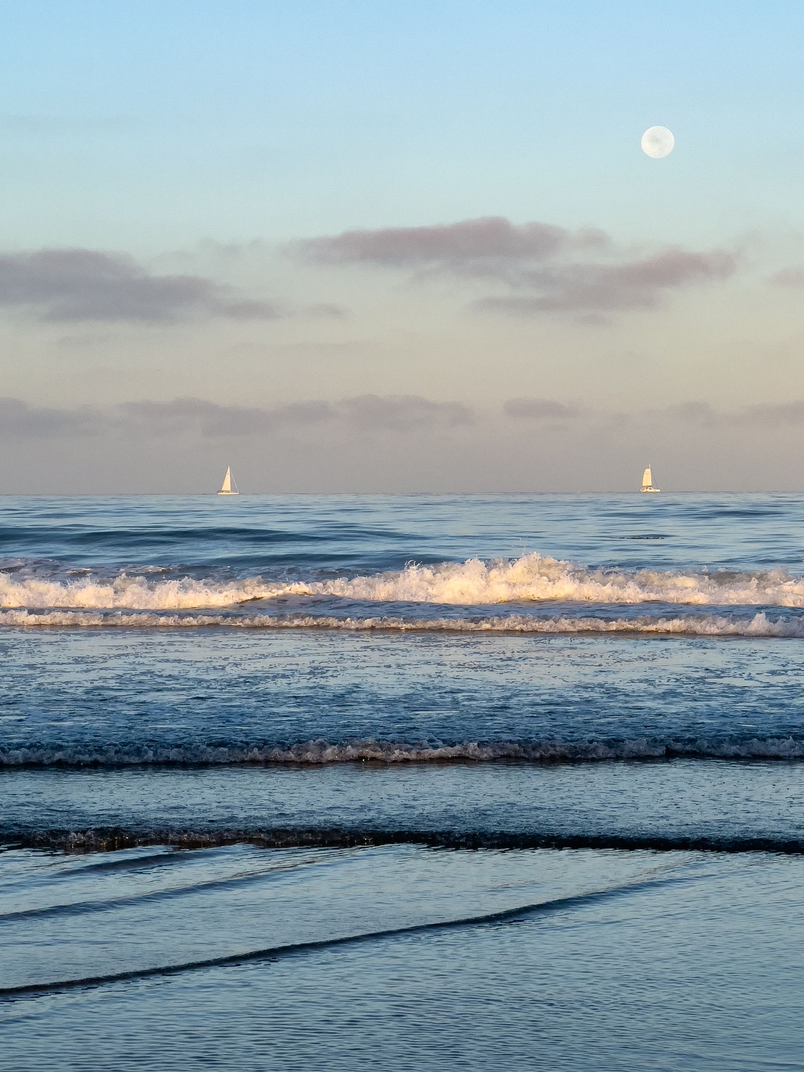 Sailboats on the San Diego coastline at sunset