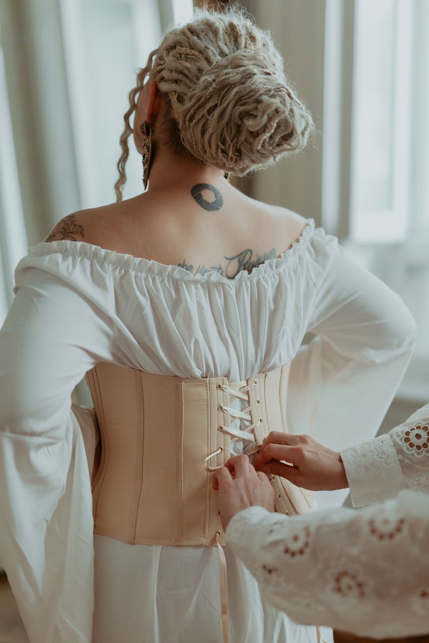 Corset lacing and adjustable structure point to bridal fashion designing for bodies that may change mid-process