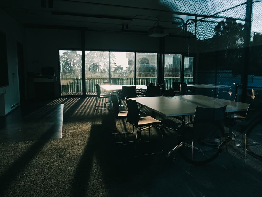 A serene empty conference room with dramatic sunlight and stylish furniture.