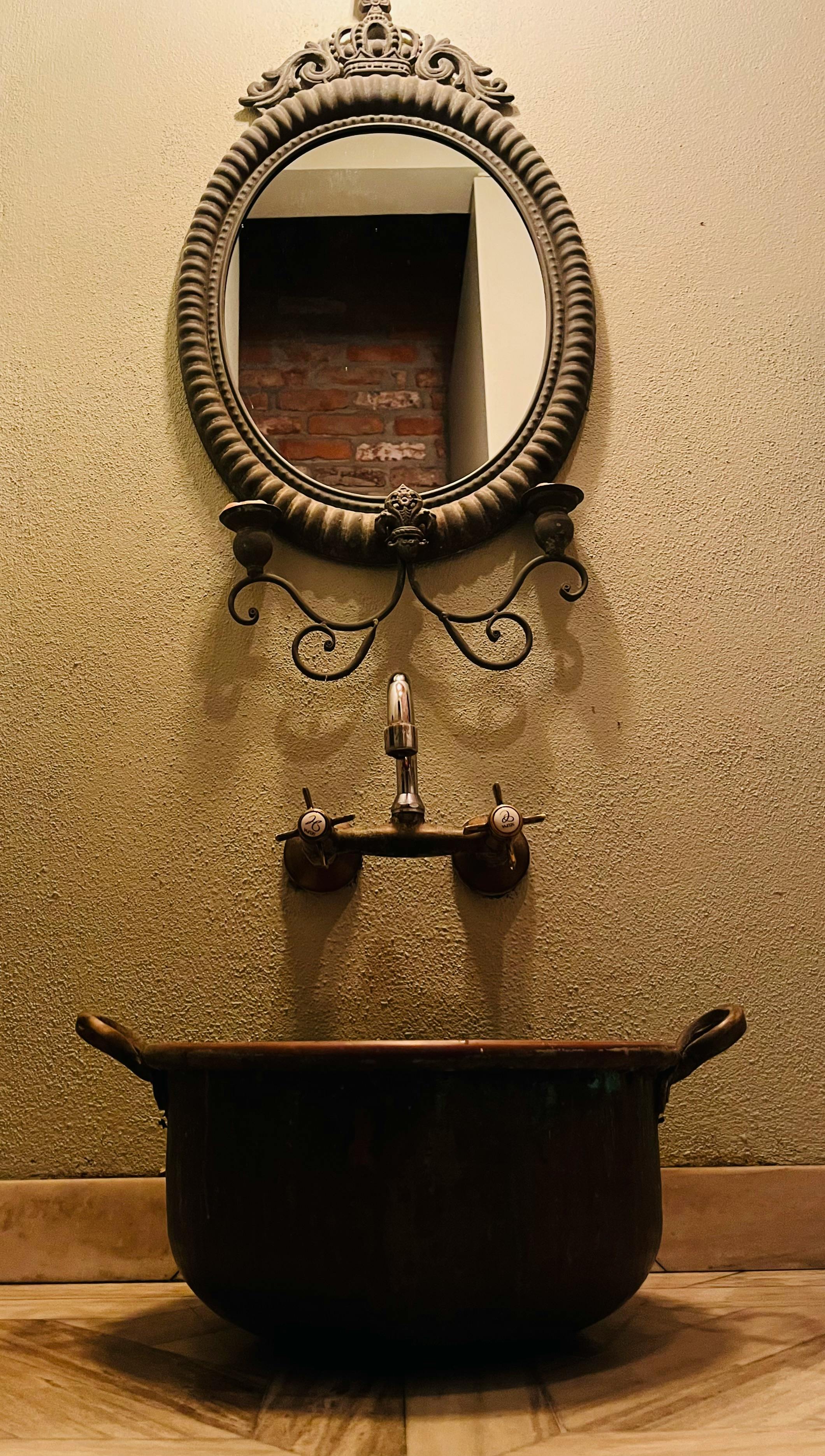 Gratis En vintage servant med utsmykket ovalt speil og klassisk armatur innendørs. Arkivbilde