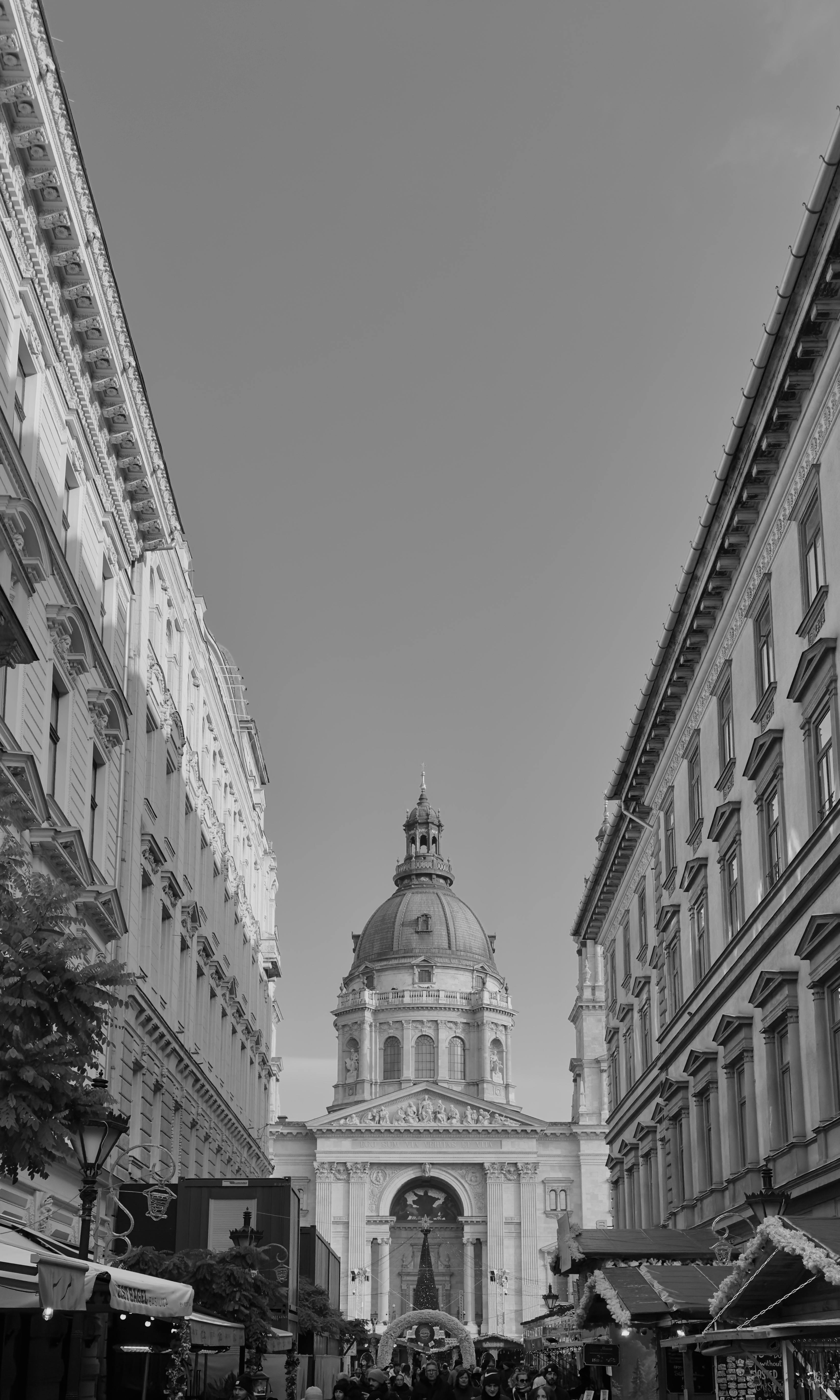 Black and white view of St. Stephen's Basilica, nestled between historic buildings in Budapest.