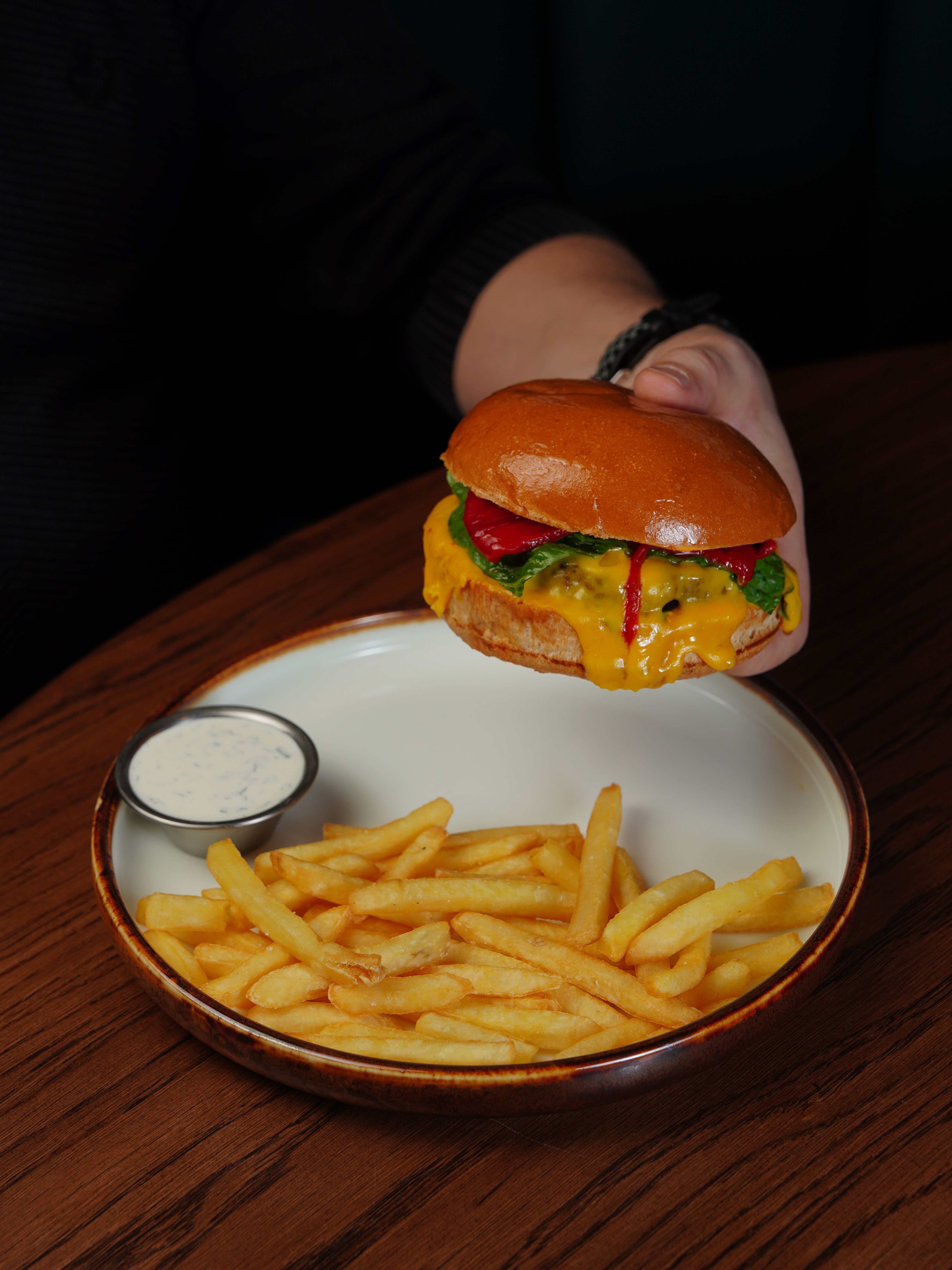 Delicious cheeseburger with fries and sauce, perfect for a casual meal.