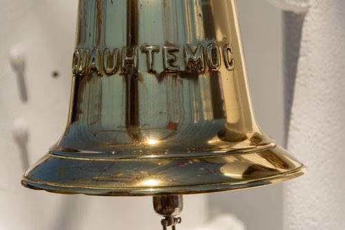 Free Brass ship bell with 'CUAUHTEMOC' inscription reflecting sunlight. Stock Photo