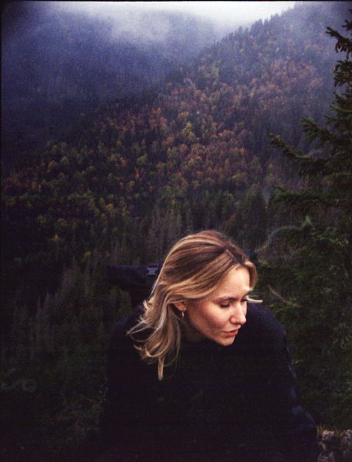Free Contemplative woman outdoors against a misty mountain backdrop, showcasing autumn foliage. Stock Photo