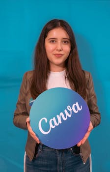 Portrait of a young woman holding a Canva logo sign, with a blue background.