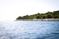 这片海景宁静宜人，岩石岛屿点缀其间，绿树成荫，海水波平如镜