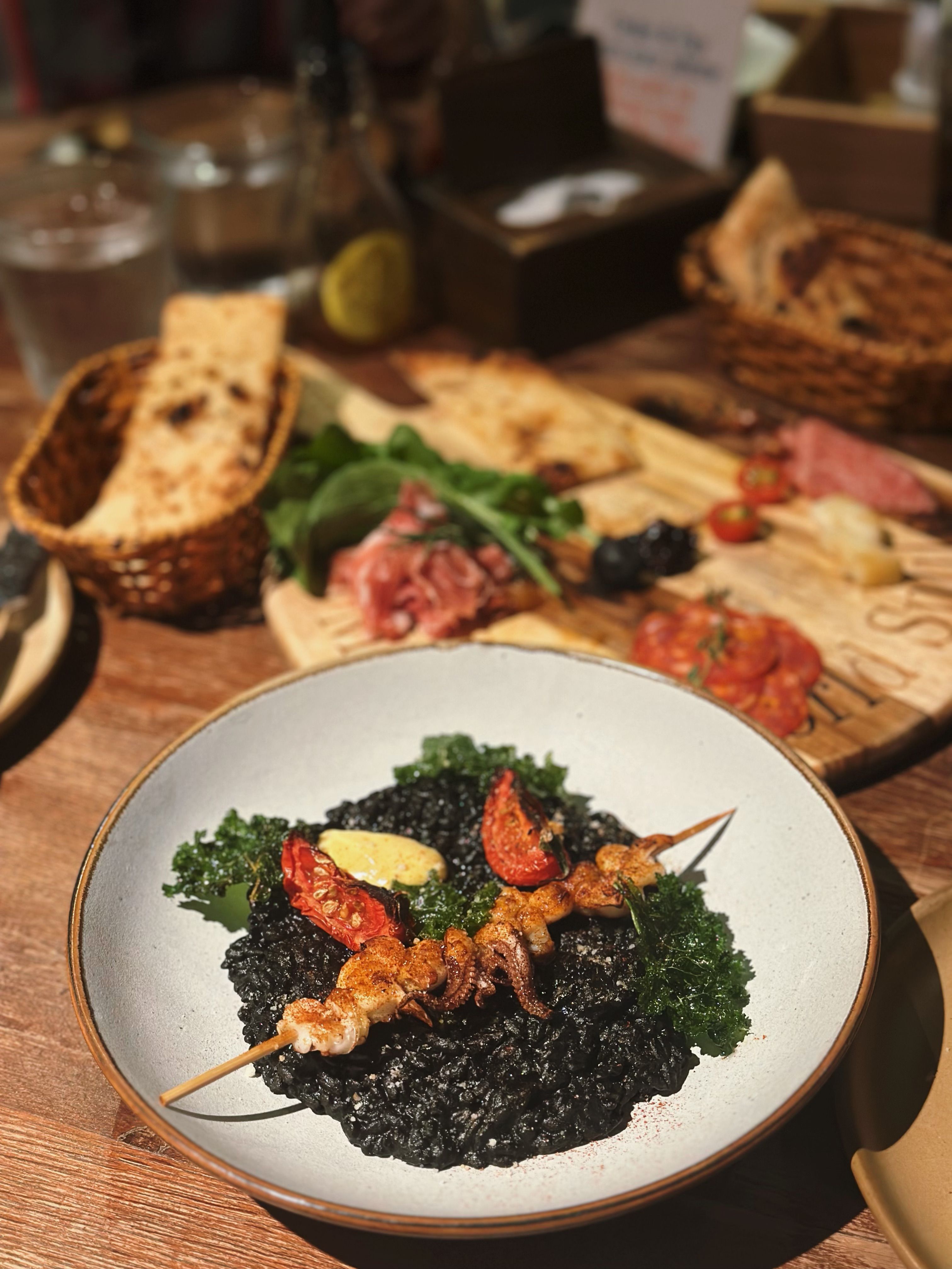 Gourmet Squid Ink Risotto with Skewered Seafood · Free Stock Photo