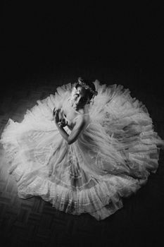 Graceful ballet dancer in a flowing dress captured in monochrome from above.