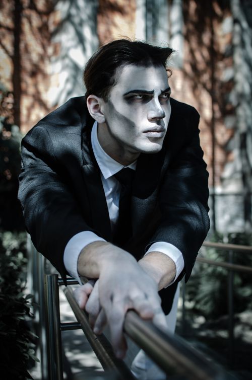 Free Man in gothic cosplay with dramatic makeup in outdoor setting, capturing theatrical essence. Stock Photo