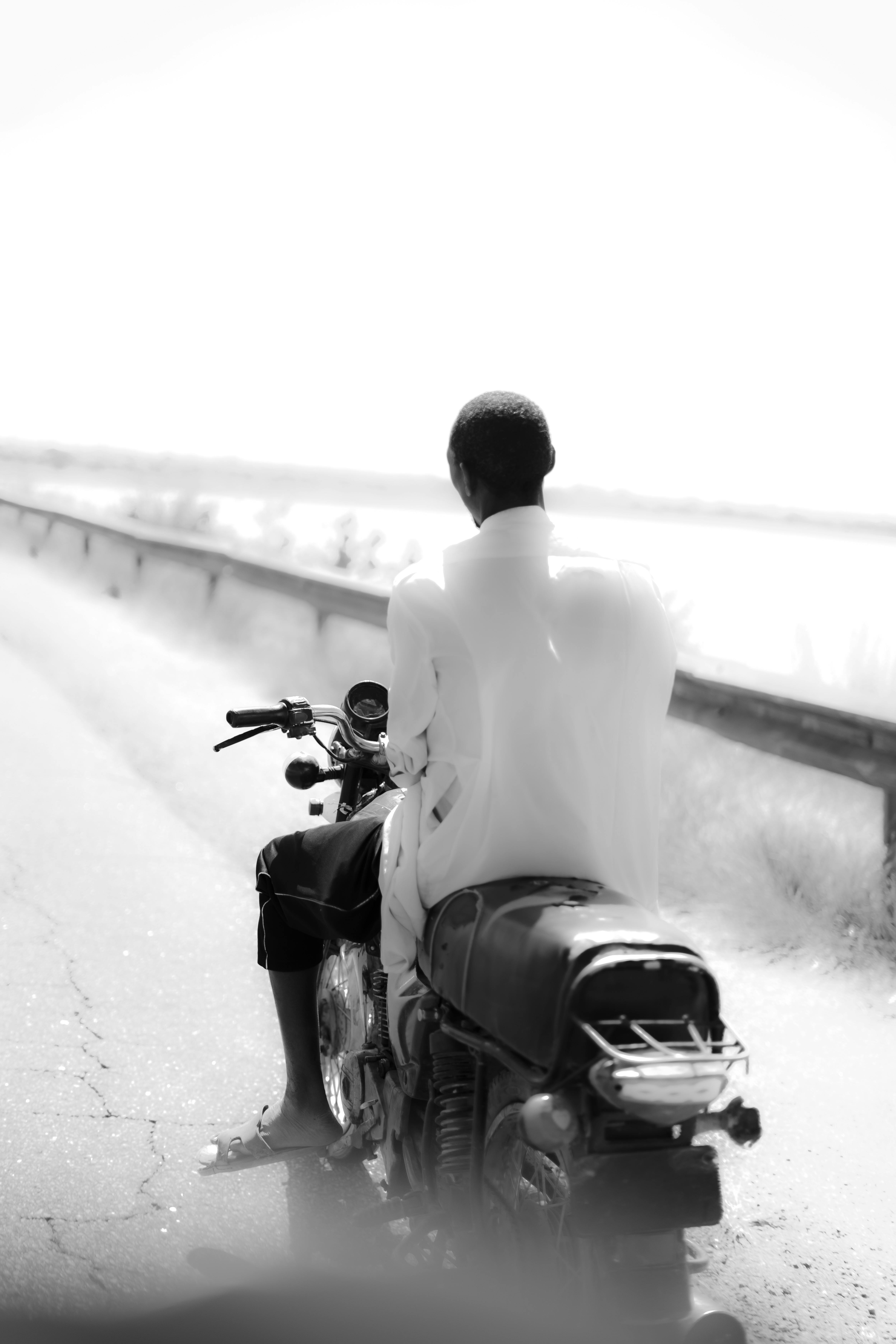 african man riding motorcycle on scenic road