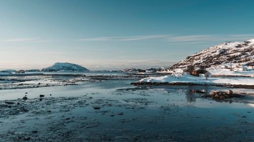 Free Serene winter landscape of a snowy fjord in Northern Norway with calm blue waters. Stock Photo