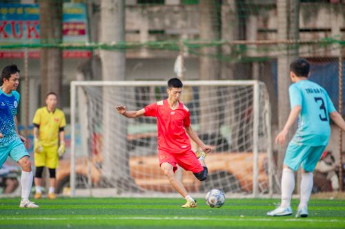 Free Exciting soccer match with athletes in bright uniforms on a vibrant field in Hà Nội, Việt Nam. Stock Photo