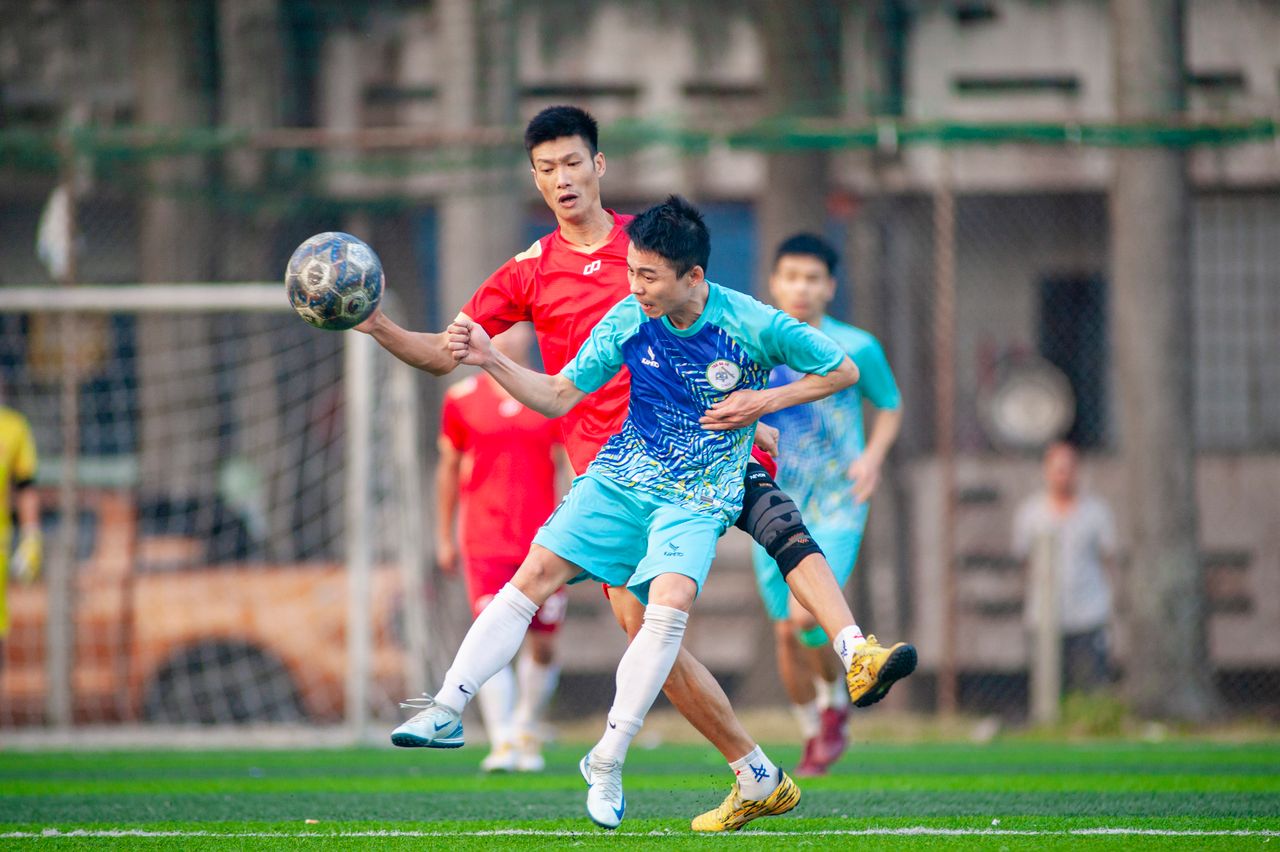 two soccer players competently tackle the ball during a match in h n i