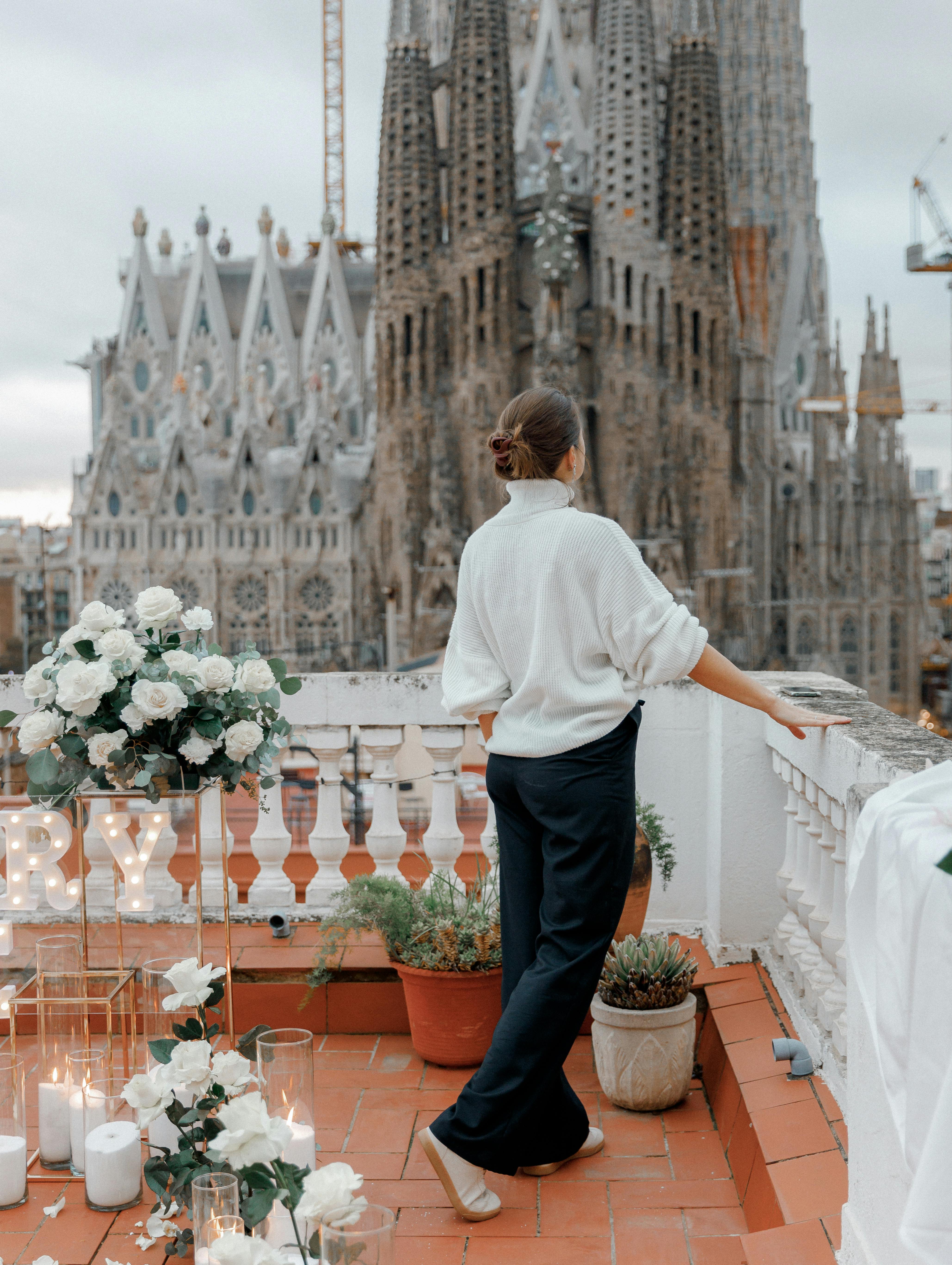 woman on rooftop overlooks sagrada familia