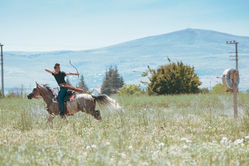 Free A skilled archer rides horseback in Konya's fields, capturing tradition. Stock Photo