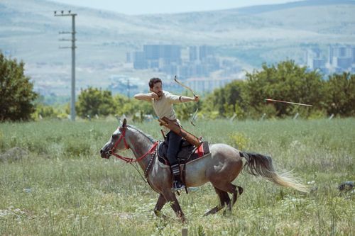 Free Dynamic scene of horseback archery in Konya, Türkiye, showcasing traditional skills in a modern setting. Stock Photo