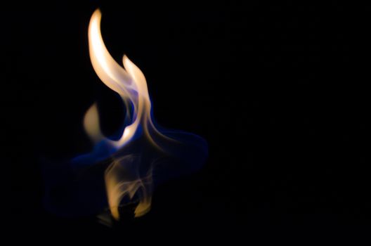 Ethereal blue and orange flames dancing against a dark background, creating a mesmerizing abstract pattern.
