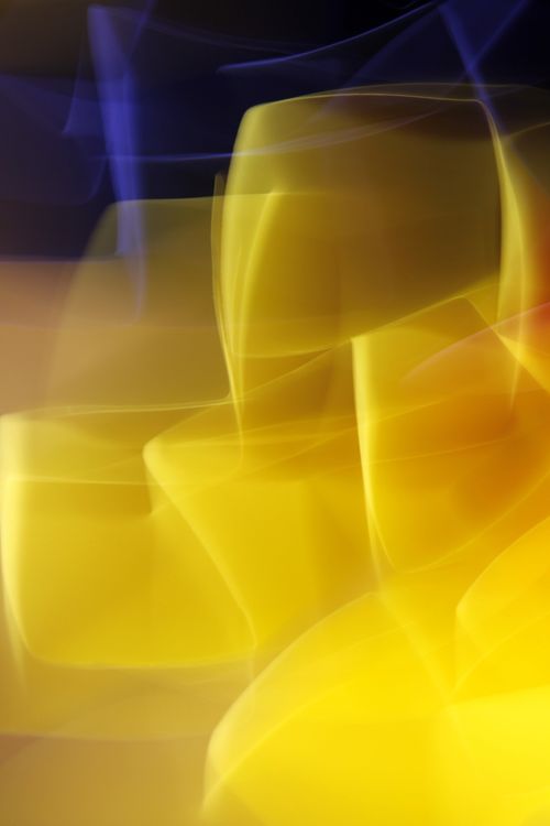 Free A vibrant abstract image featuring dynamic yellow and blue light streaks. Stock Photo