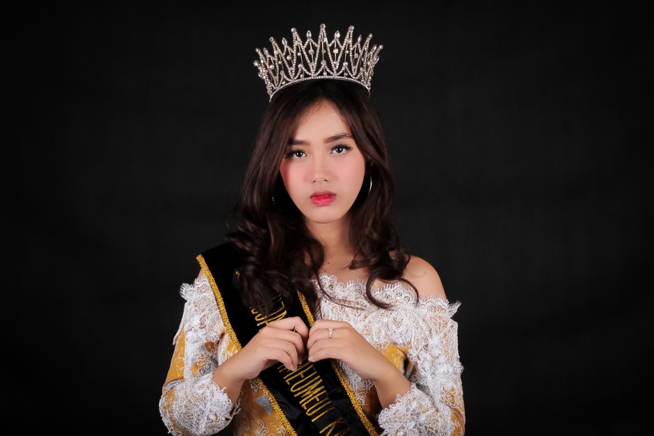Stunning portrait of a woman in a tiara and sash at a pageant.