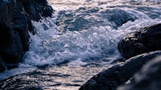 汹涌的海浪拍打着崎岖的岩石海岸线，展现了大自然的力量