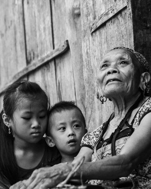 Grayscale Photography Of Woman Beside Children