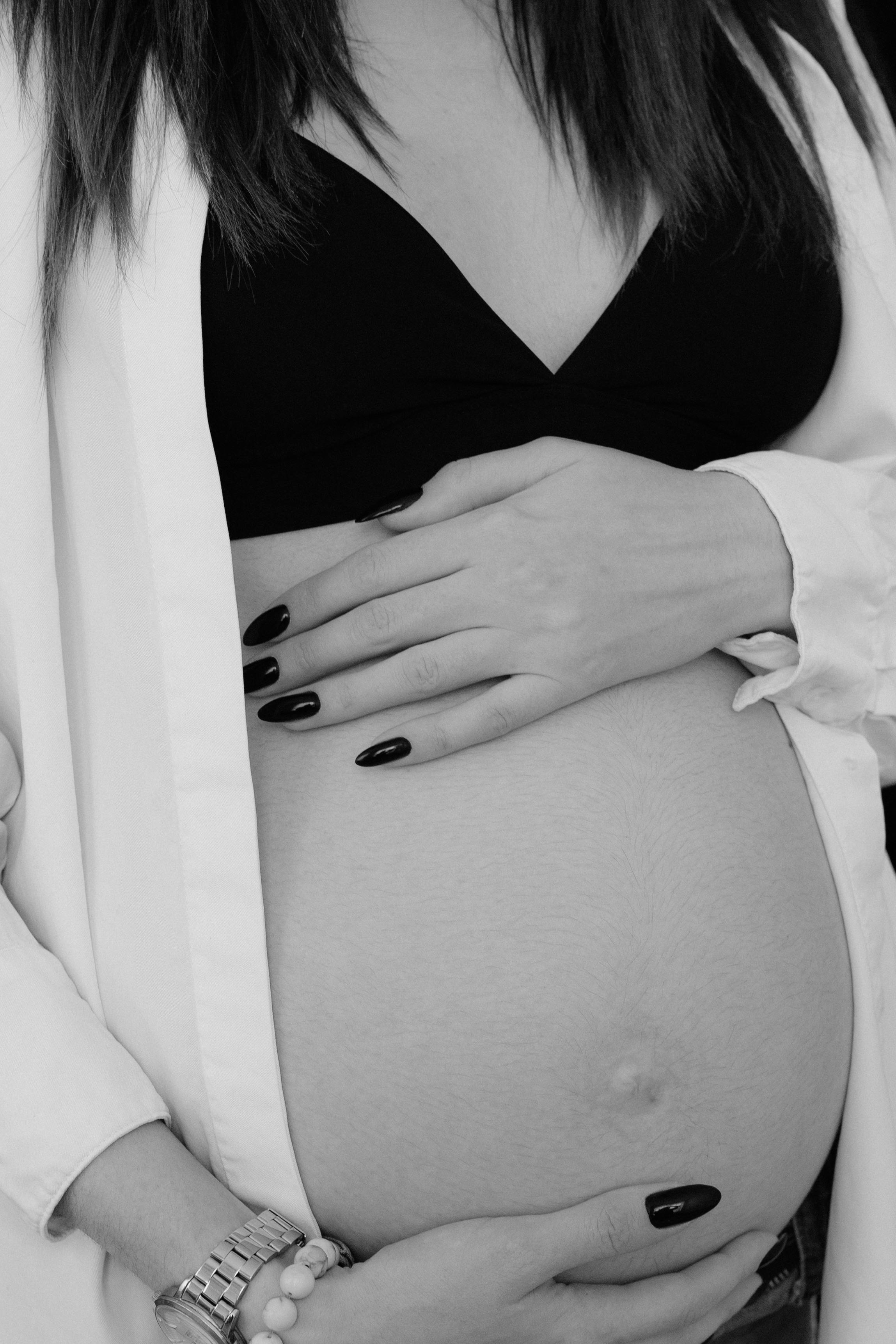 Kostenlos Schwarzweißbild einer schwangeren Frau, die sanft ihren Bauch hält. Stock-Foto