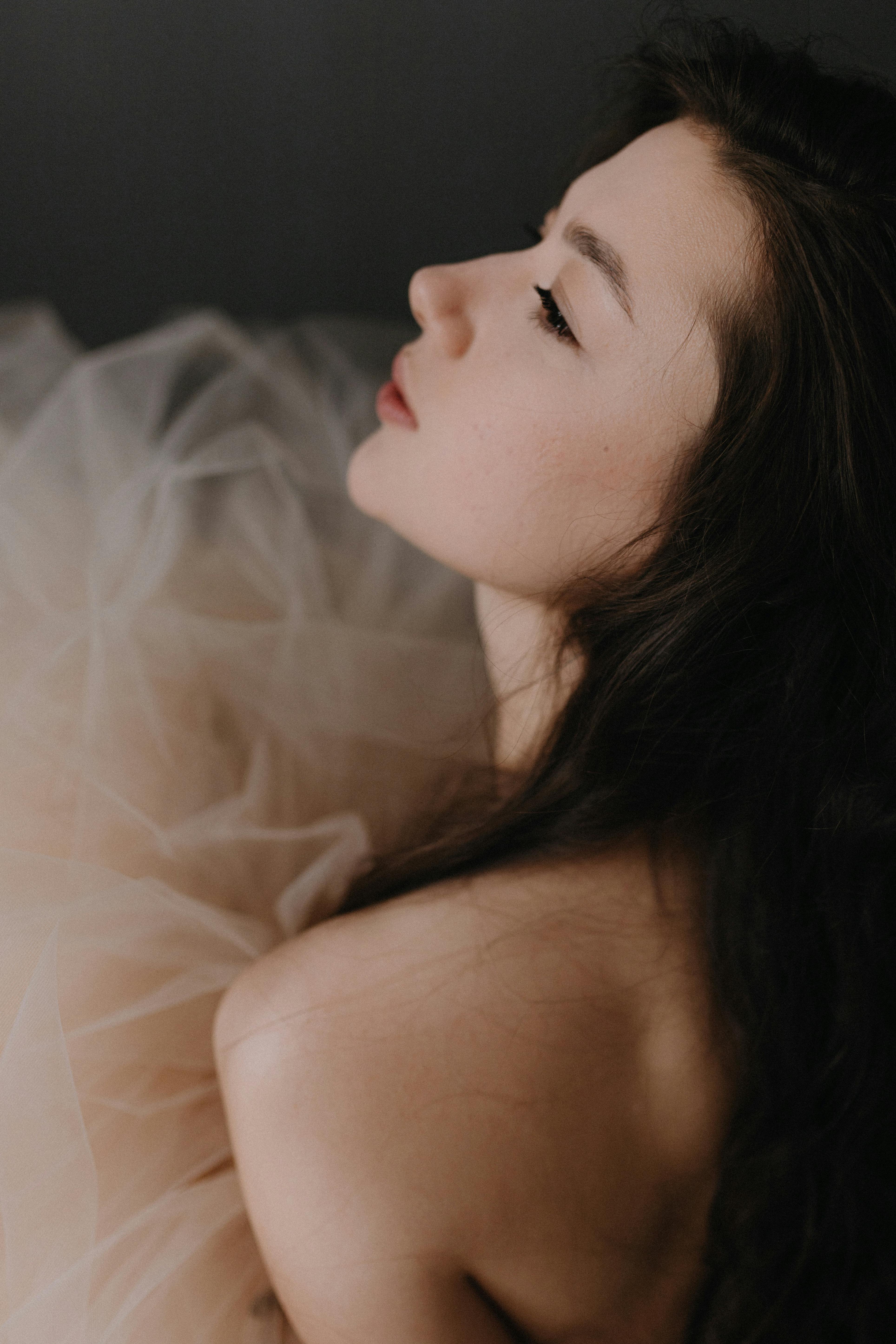 Side profile of a young woman in soft lighting, with a dreamy and elegant mood.