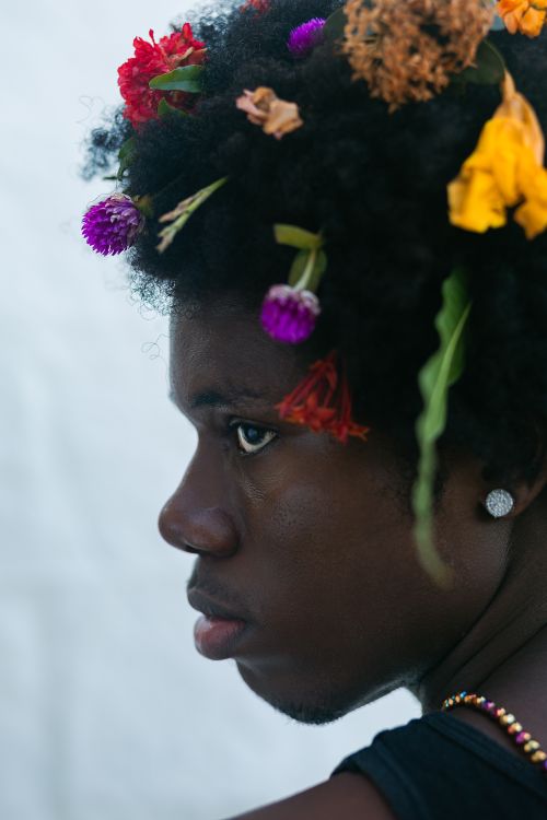 Gratis Ritratto artistico di profilo di un giovane adornato con fiori colorati tra i capelli. Foto a disposizione