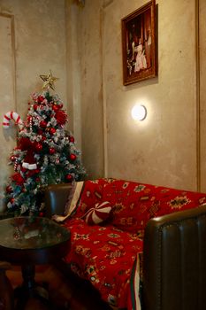 Warm and festive living room featuring a Christmas tree and decorated couch.