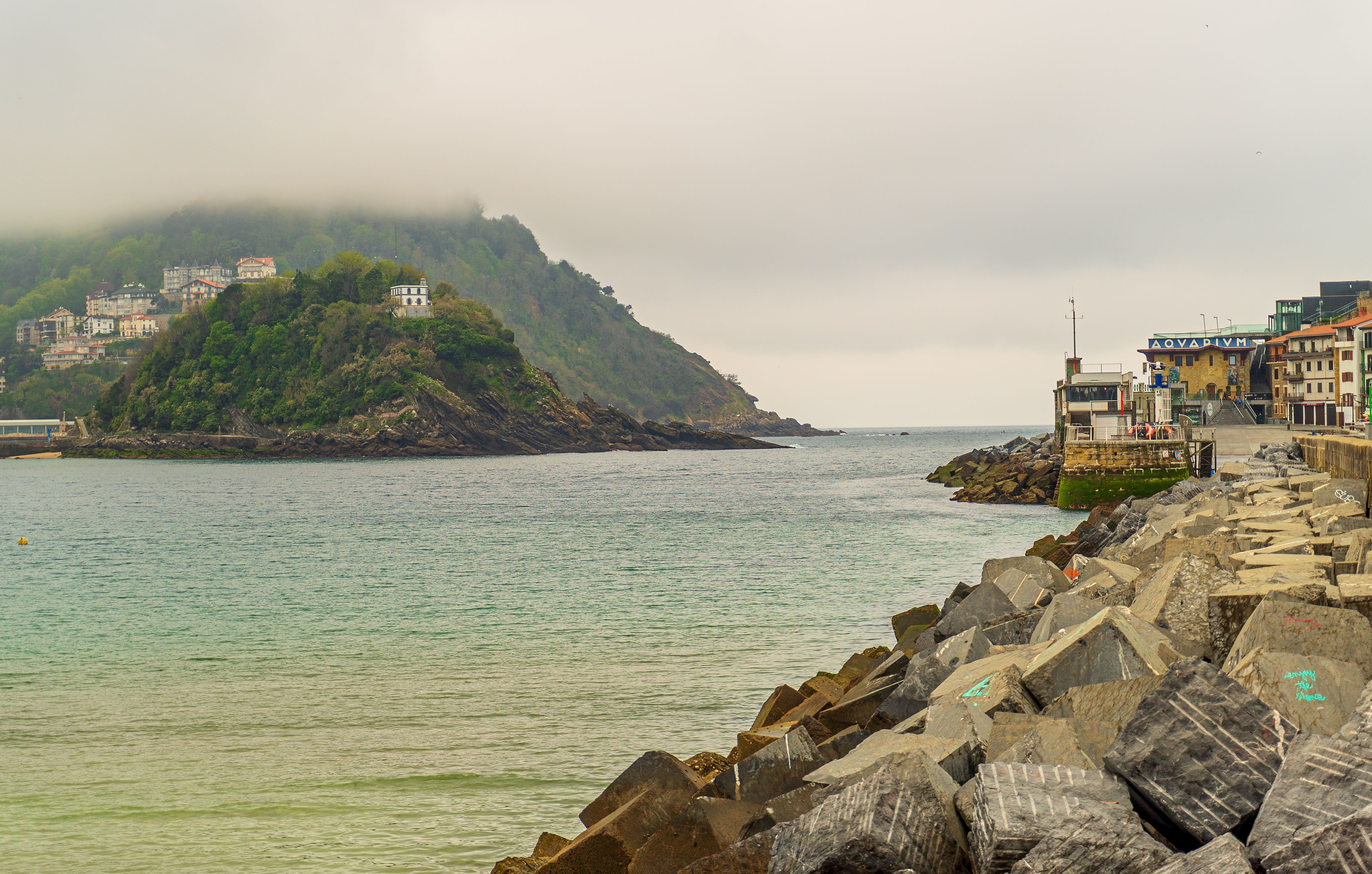 Beautiful view of a rocky coast along a calm ocean under a cloudy sky.