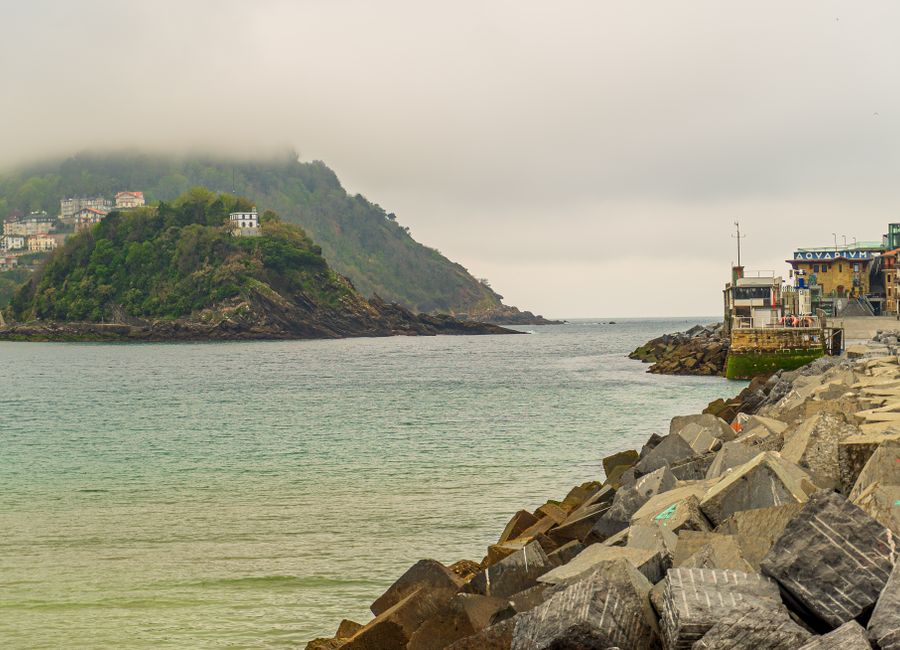 Beautiful view of a rocky coast along a calm ocean under a cloudy sky.
