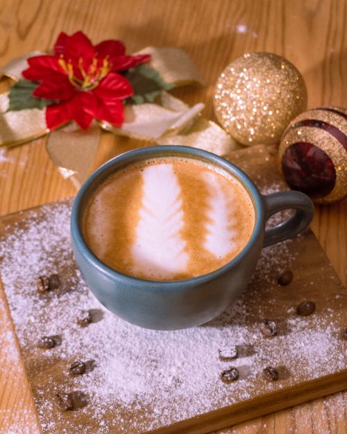 Free Latte art coffee with festive Christmas decor in Santiago, creating a cozy holiday café atmosphere. Stock Photo
