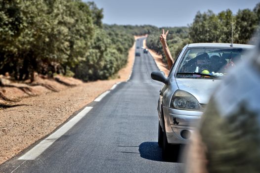 A car journey through scenic Ifrane, Morocco, with a playful peace sign gesture.