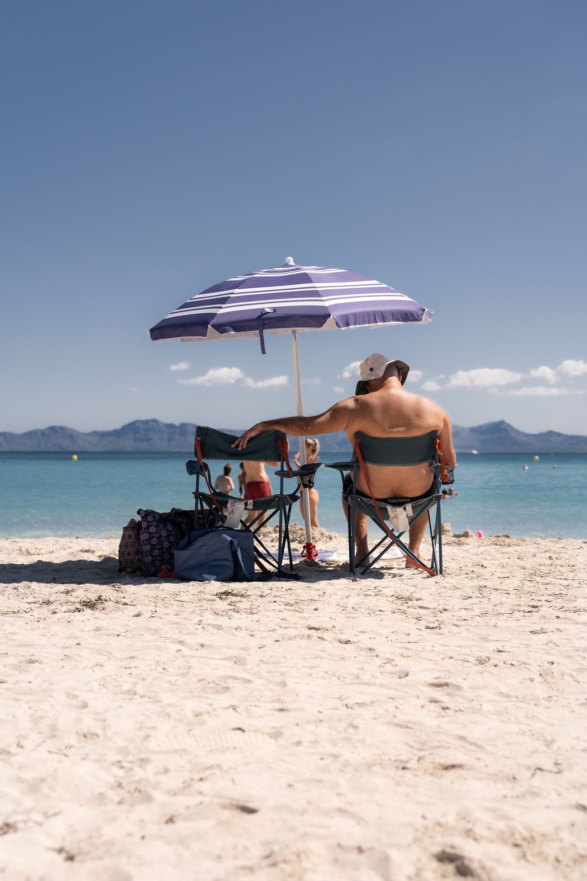 Family relaxing together in the shade beside the sea